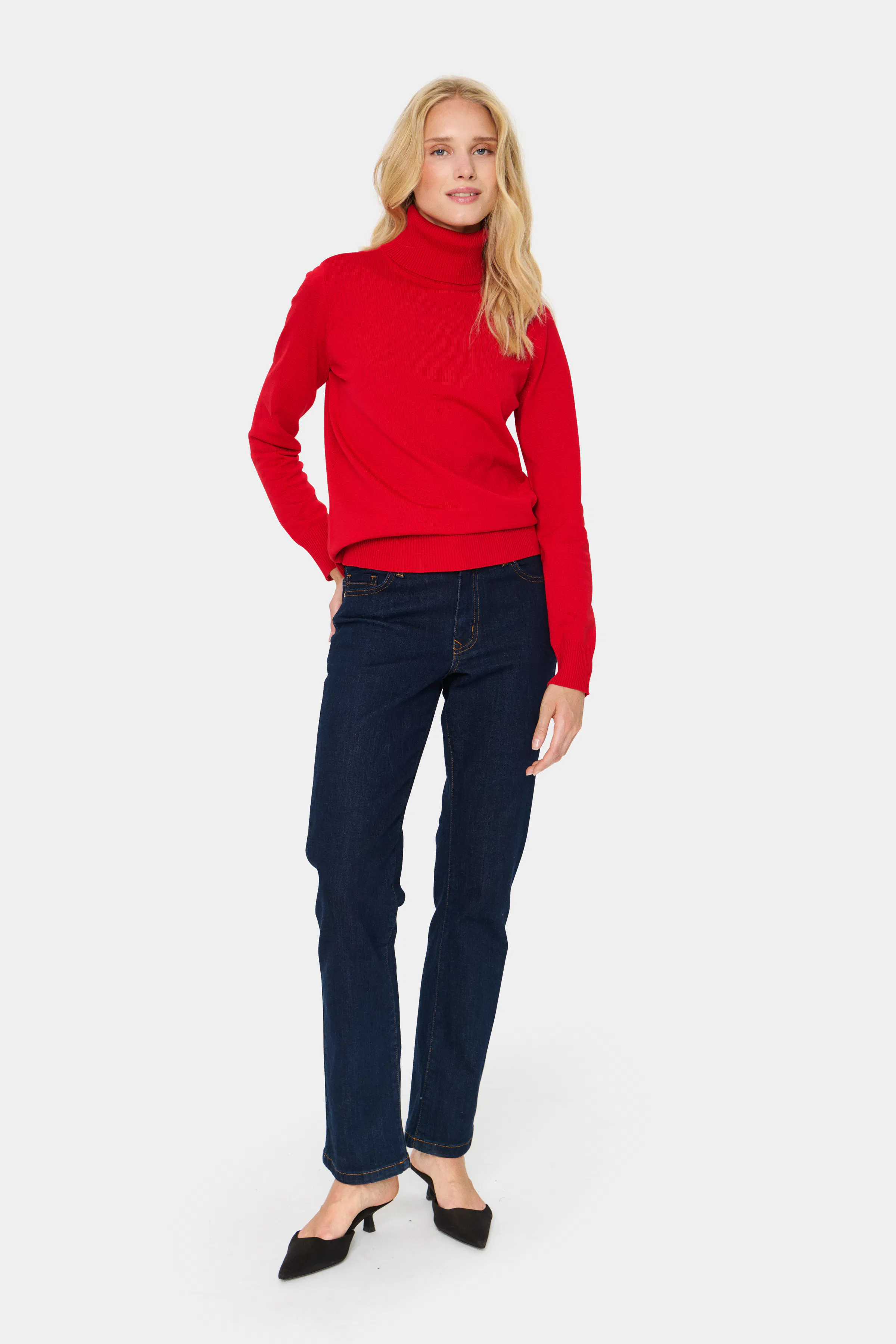 Woman in red turtleneck sweater and dark jeans winter outfit